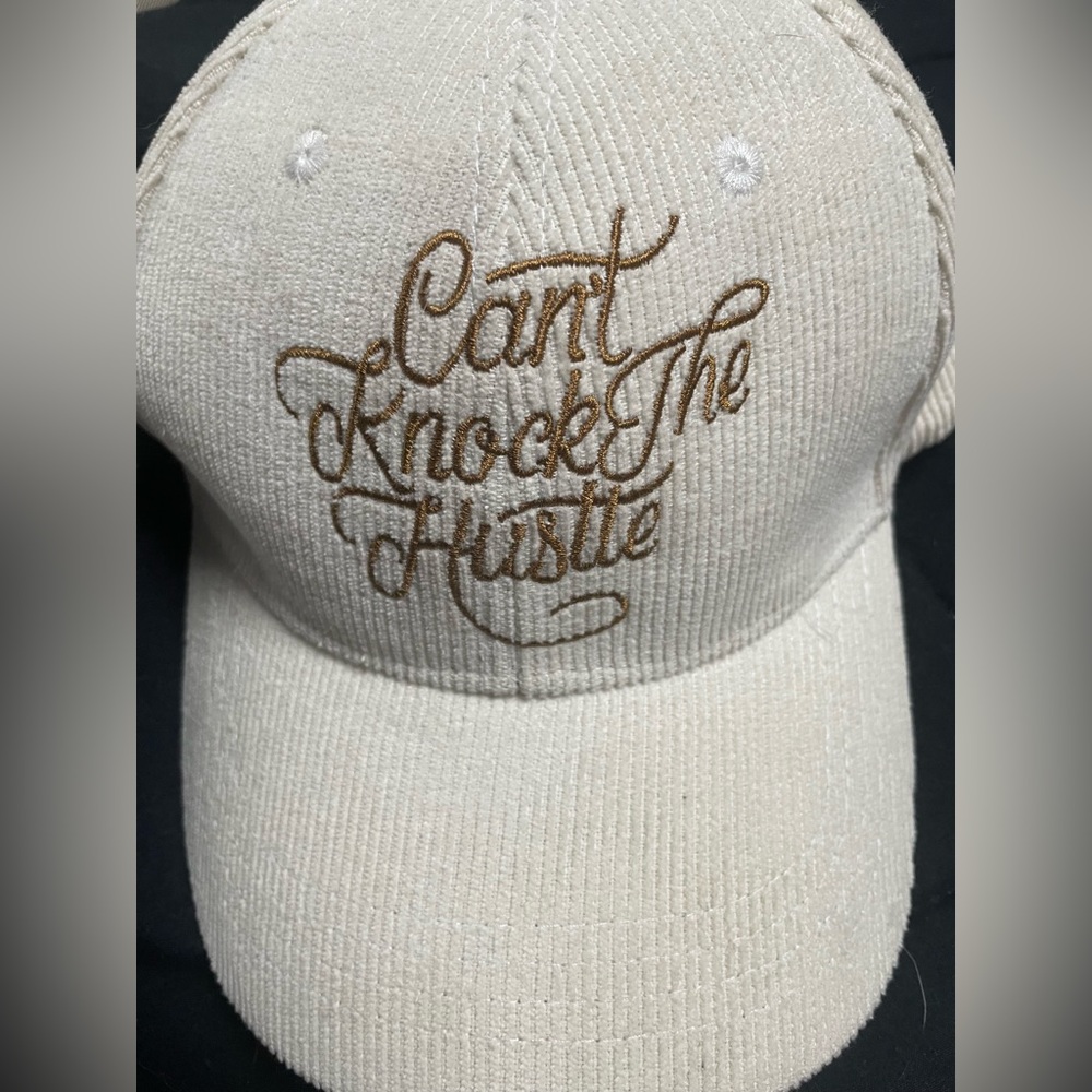 “Can’t knock the hustle” corduroy hat. White with gold lettering.
